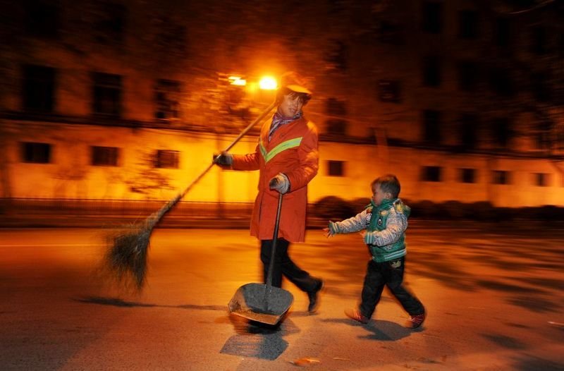 2011年，武汉的一位环卫工人每天带着3岁的孙子扫马路